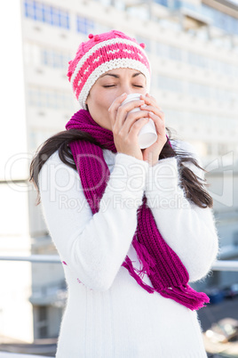 Smiling woman drinking from white cup