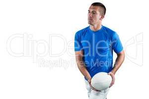 Serious rugby player in blue jersey holding ball