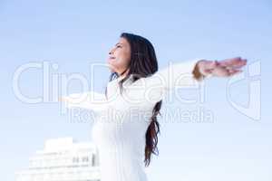 Pretty brunette feeling the air with arms raised up