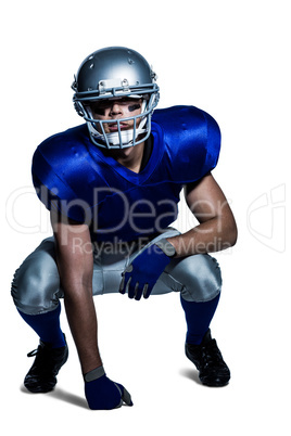 American football player in uniform crouching