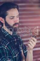 Hipster holding smoking pipe