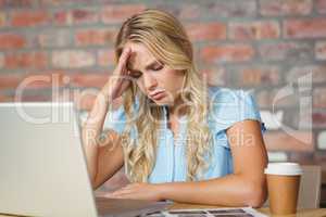 Stressed woman sitting in front of laptop