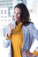 Beautiful woman drinking a coffee with hand on hip