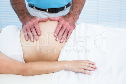 Therapist massaging belly of pregnant woman