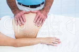 Therapist massaging belly of pregnant woman