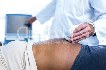 Doctor performing ultrasound on pregnant woman in clinic