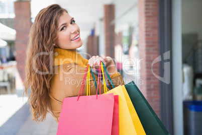 Portrait of smiling woman with shopping bags looking at camera