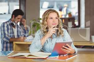 Thoughtful businesswoman with tablet in office