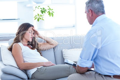 Thearapist advising pregenat woman on sofa