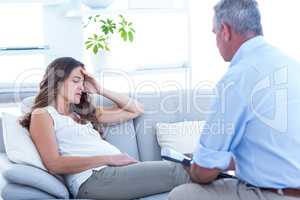 Thearapist advising pregenat woman on sofa