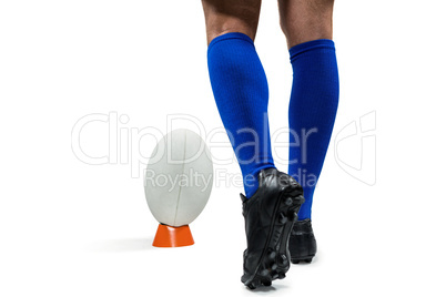 Low section of rugby player about to kick the ball