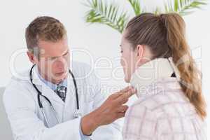 Doctor examining patient wearing neck brace