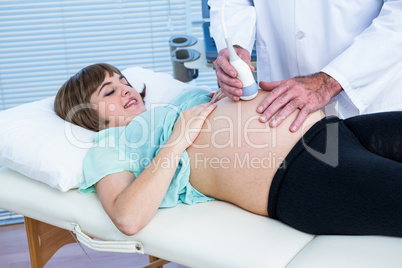 Doctor performing ultrasound on smiling woman