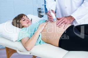 Doctor performing ultrasound on smiling woman