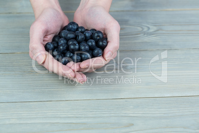 Woman showing handful of blueberries