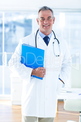 Portrait of male doctor with document in hospital