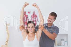 Doctor stretching a young woman arm