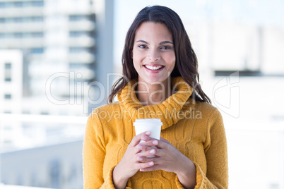 Beautiful woman drinking a coffee and smiling at camera