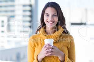 Beautiful woman drinking a coffee and smiling at camera