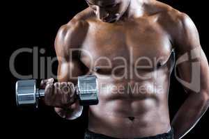 Mid section of muscular athlete exercising with dumbbell