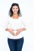 Portrait of smiling pregnant woman touching abodomen