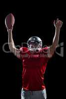 American football player cheering while holding ball