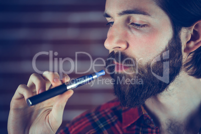 Serious hipster holding electronic cigarette