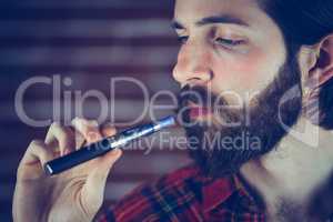 Serious hipster holding electronic cigarette