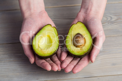 Woman showing fresh avocado