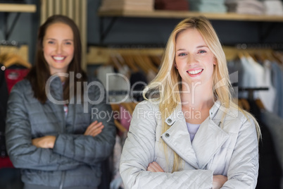 Smiling blonde with arms crossed looking at camera with friend b