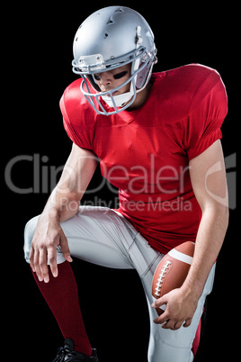 American football player with hand on knee