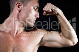 Close-up handsome shirtless athlete flexing muscles