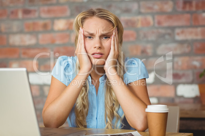 Portrait of frustrated woman sitting in front of her notebook