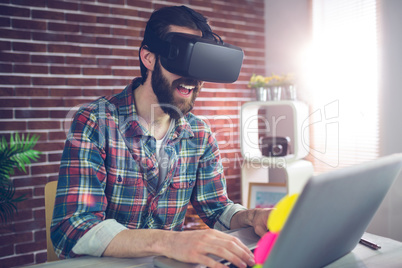 Happy creative businessman wearing 3D video glasses at office
