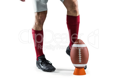 Low section of sportsman kicking ball