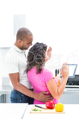 Happy couple gesturing while holding digital tablet