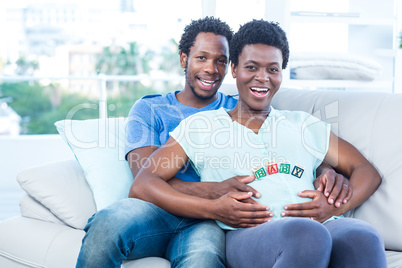 Portrait of happy couple sitting on couch