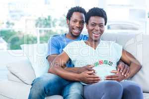 Portrait of happy couple sitting on couch