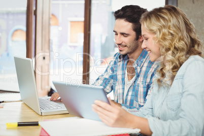 Man showing laptop to woman