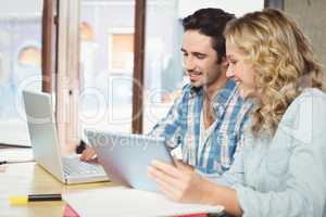 Man showing laptop to woman