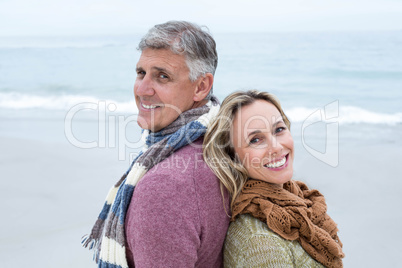 Happy couple standing back to back