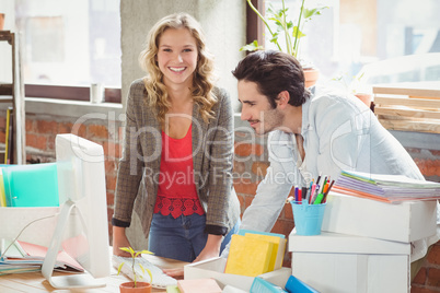 Portrait of smiling businesswoman standing by colleague in offic