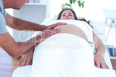 Masseur providing massage to pregnant woman