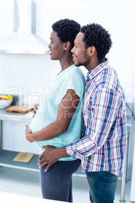 Man embracing his happy pregnant wife