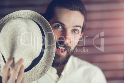 Surprised man holding hat