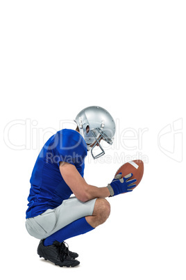 Profile view of American football player in attack stance