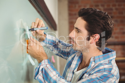 Handsome businessman writing on notes in office