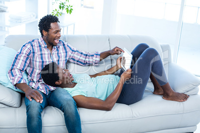 Couple laughing and looking at tablet