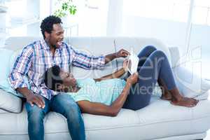 Couple laughing and looking at tablet