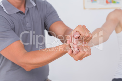 Doctor stretching a young woman arm